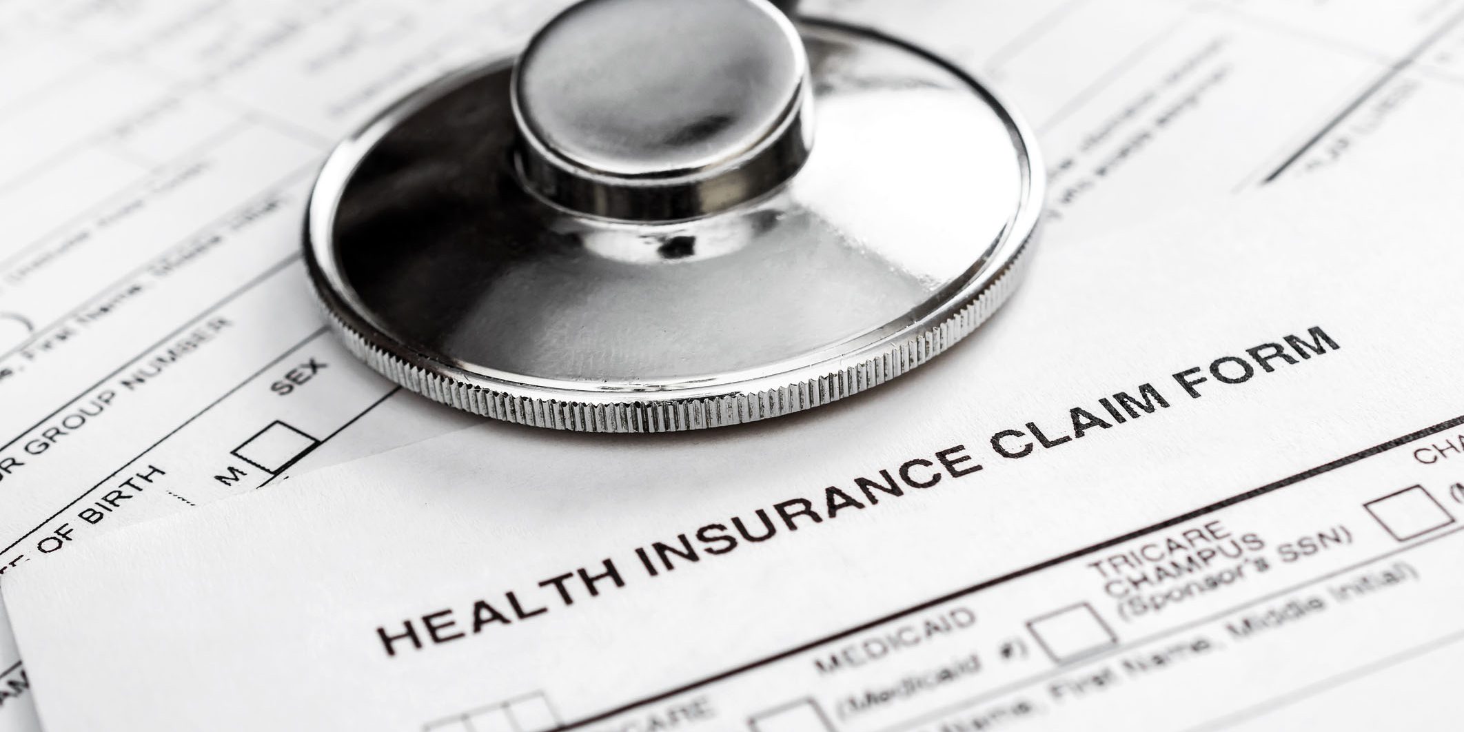 Stethoscope on health insurance claim form. Close up.