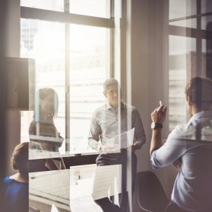 Business people having discussion in board room A photo of business people having discussion in board room. Male and female professionals are seen through glass. They are working in office.