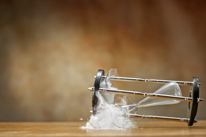 Broken hourglass with white sand