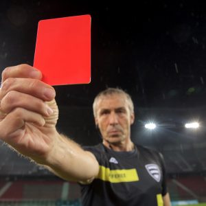 Cal/OSHA Proposed Rules Would Impose Large Penalties for 'Egregious,' 'Enterprise-Wide' Violations Portrait of referee showing red card during football match.