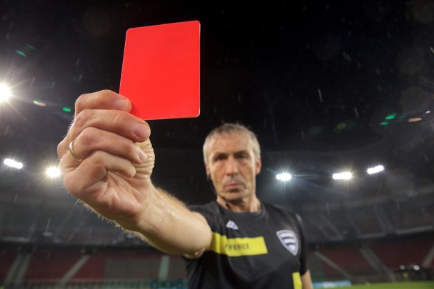 Cal/OSHA Proposed Rules Would Impose Large Penalties for ‘Egregious,’ ‘Enterprise-Wide’ Violations Portrait of referee showing red card during football match.