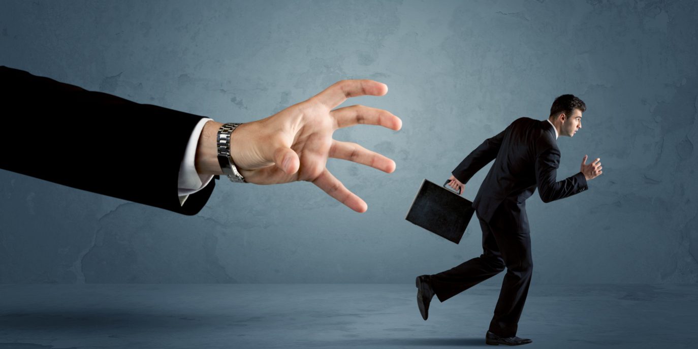 Business man running away from a huge hand concept fraud